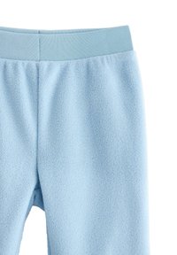 Vaaleansiniset fleece-housut, joissa on tekstuuripinta, vahvistettu elastinen vyötärö ja hieman kapeneva lahjesuunnittelu.