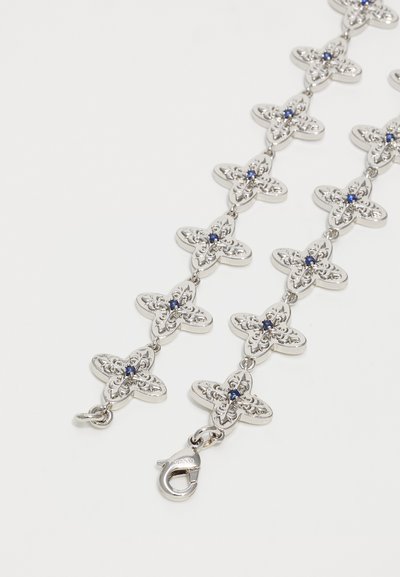 Silver chain necklace with interconnected floral links, each featuring a blue gemstone center, and a lobster clasp closure.
