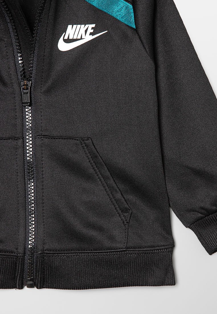 Schwarze Nike Zip-Jacke mit Fronttaschen, gerippten Bündchen und einem türkisen Akzent nahe der Schulter auf der rechten Seite.