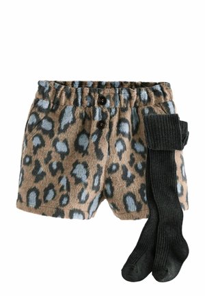 Shorts en peluche à imprimé léopard avec une ceinture élastique et deux boutons, associés à des collants noirs côtelés pliés.