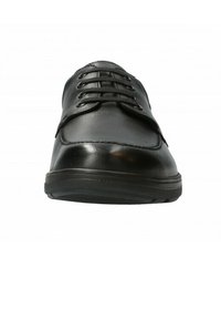 Chaussure en cuir noir avec un bout arrondi, un laçage à cinq œillets et une semelle en caoutchouc texturée. Présente une surface lisse avec une couture subtile.