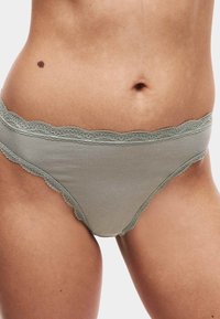 Helle grüne Baumwoll-Bikiniunterwäsche mit einem gewellten Spitzenrand an der Taille und den Beinen, entworfen für Komfort und eine enge Passform.