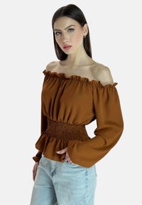 Braunes schulterfreies Oberteil mit gerafftem Ausschnitt, gesmokter Taille und langen, voluminösen Ärmeln. Glattes Material mit leichtem Glanz.