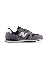 Zapatillas deportivas grises y negras con parte superior de ante y malla, acentos en blanco, cordones redondeados y suela acolchada. Logo "N" en el lateral destacado.