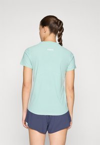 Lettvekts mintgrønn treningsskjorte med korte ermer, detalj ved bakseam og HOKA-logo. Kombinert med marineblå shorts. Glatt stofftekstur.