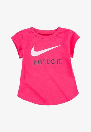Camiseta rosa de manga corta hecha de algodón suave. Cuenta con un logotipo de Nike en blanco y "JUST DO IT" en texto negro, con un escote redondo.