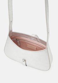 Harmaa teksturoitu nahkainen olkalaukku, jossa on vaaleanpunainen kangasvuori, sisällä vetoketjullinen tasku ja magneettiklipisuljenta edessä.