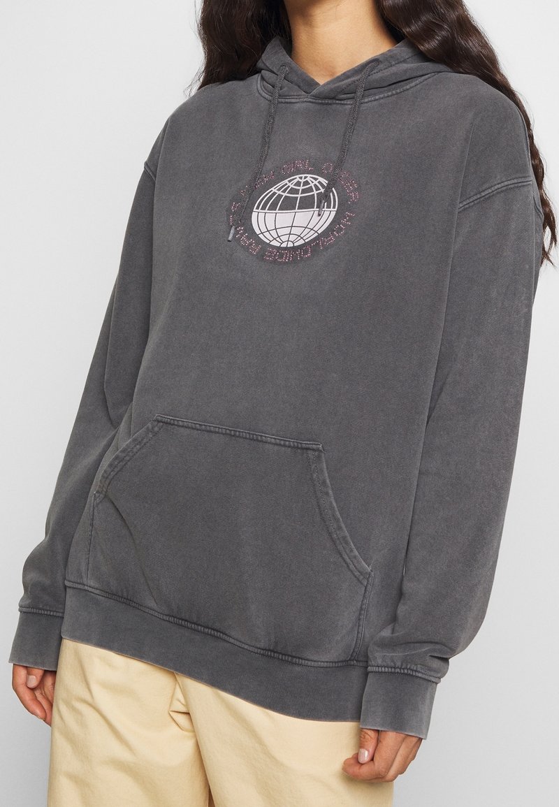 Grå hoodie i mjukt tyg, med en framficka, dragsko-huva och en globgrafik med text i rosa. Avslappnad passform och strukturerad yta.