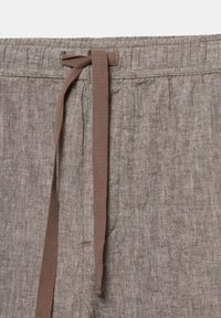 Bruine linnen broek met een elastische tailleband en een bijpassend stoffen trekkoord dat vooraan in het midden eenvoudig is gestrikt.