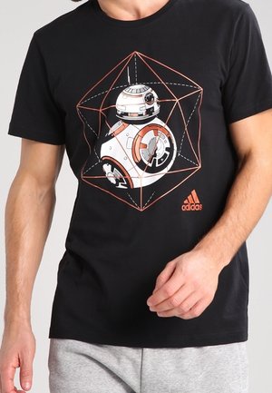 Schwarzes T-Shirt mit einem Grafikdesign eines Roboters aus geometrischen Formen. Hergestellt aus Baumwolle mit kurzen Ärmeln; Adidas-Logo in Orange unten rechts.