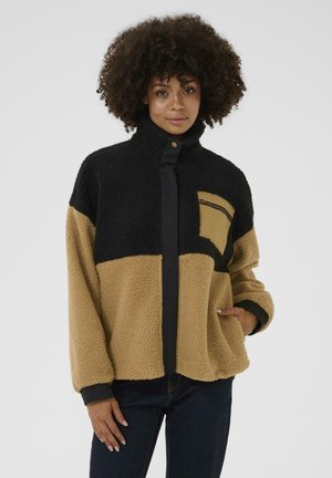 Veste en polaire avec un design coloré en blocs comprenant du noir, du beige et du marron. Fermeture éclair intégrale, col montant, et une poche zippée à l'avant sur la poitrine gauche.