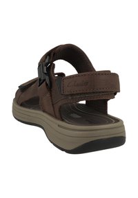 Ruske kožne sandale s podesivim trakama, udobnim uloškom i debelim, teksturiranim gumenim đonom za poboljšano prianjanje.