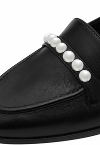 Pantofi loafers din piele neagră, cu o textură netedă și o bandă decorată cu perle albe lucioase pe partea superioară. Design structurat, cu detalii de cusătură.