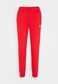 Červené tepláky vyrobené z jemného materiálu, s elastickým pasem na šňůrku, zúženými nohavicemi a malým bílým logem Nike na boku.