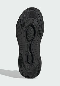 Black rubber sneaker sole with textured patterns, featuring circular and oval shapes for traction. Includes branding on the side.