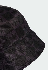 Chapeau seau noir à motif écossais avec des logos en relief. Fabriqué en tissu texturé, il possède un bord flexible et un design sans couture.