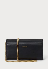 Melna ādas rokassoma ar zeltītu ķēdes siksnu, kas izceļas ar strukturētu dizainu un izspiestu logotipu uz priekšpuses. Gluda tekstūra bez redzamām rakstainām izvēlēm.