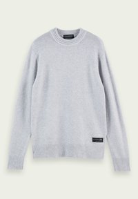 Pull gris clair en tissu doux, avec un col rond, des poignets et un ourlet côtelés, et une étiquette décorative en bas à gauche.