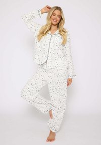 Set di pigiama bianco con motivo a stelle blu, composto da maglia a maniche lunghe con chiusura a bottoni e pantaloni con cintura elastica, con bordo a contrasto.