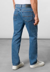 Niebieskie dżinsy z prostą nogawką, z dwoma tylnymi kieszeniami oraz skórzaną metką marki na pasie. Standardowe detale przeszycia.