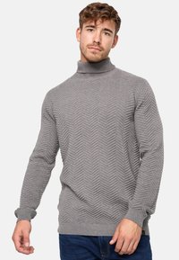 Sivi pulover s rolkragnom s teksturiranim uzorkom riblje kosti, rebrastim manžetama i rubovima, napravljen od mekanog pletenog materijala. Dobro prianja.