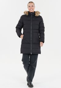 Sort pufferjakke med en hætte med pelskant, features lynlås foran, to store forlommer og et knælængde design.