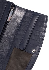Interior de billetera de cuero azul marino con ranuras para tarjetas, un bolsillo con cierre y una sección de malla. Presenta una textura brillante y costuras en contraste.