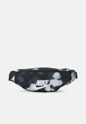 Sac banane tie-dye noir et blanc avec fermeture éclair frontale et logo Nike blanc centré sur le panneau avant.