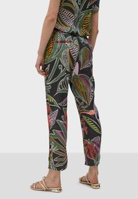 Černé kalhoty s květinovým vzorem a zúženým střihem, vyrobené z lehkého materiálu. Mají mnohobarevné listy a stahovací pas.