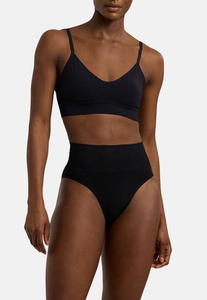 Schwarzer Bralette mit dünnen Trägern und einer glatten, weichen Textur, kombiniert mit hochgeschnittenen schwarzen Slips mit nahtlosem Design und elastischem Bund.