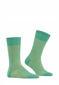 Grüne Socken aus einem glatten, dehnbaren Material mit vertikalen Rippungen und einem kontrastierenden hellgrünen Akzent am Bund und an der Ferse.
