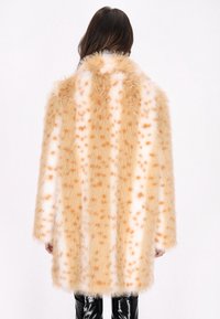 Cappotto in pelliccia sintetica arancione e bianco, con motivo maculato, vestibilità ampia e lunghezza media. Tessuto morbido con ampio collo.