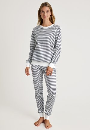 Gestreiftes Pyjama-Set in Weiß und Marineblau, mit langen Ärmeln und rundem Halsausschnitt. Gerippte Bündchen und Knöchelabschlüsse sorgen für Details. Weiches Gewebe.