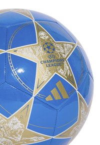 Modrý fotbal s hvězdným vzorem a zlatými akcenty, včetně loga UEFA Champions League a značky Adidas.