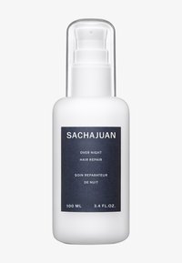 Vit flaska med pumpdispenser; har en mörkblå etikett med text. Kapacitet: 100 mL (3,4 fl. oz). Lämplig för nattlig hårreparation.