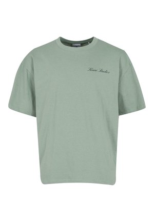 T-shirt oversized vert menthe en coton doux, avec un col rond et un petit logo brodé sur la poitrine gauche.
