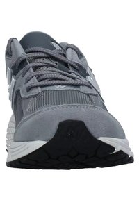 Gray athletic shoe featuring a mesh and suede upper, textured laces, padded collar, and a rubber outsole with a hexagonal tread pattern.