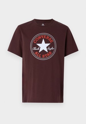 Ciemnobrązowy krótki rękaw T-shirt z białym logo w kształcie gwiazdy oraz czerwonym napisem "Converse All Star" i "Chuck Taylor" na środku przodu.