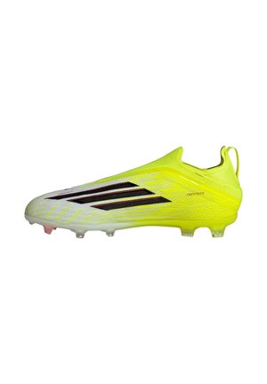Chaussure de football jaune et blanche avec des rayures noires, design sans lacets et surface texturée portant l'inscription "FIBERTOUCH" sur le côté.