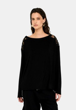 Maglietta nera a maniche lunghe con dettagli in pizzo sulle spalle, scollatura ampia e vestibilità rilassata. Tessuto morbido con una texture liscia.