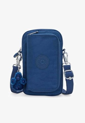 Bolso bandolera azul marino de tela duradera con un acabado texturizado. Cuenta con cierre de cremallera, parche con el logo y un llavero de mono peludo adjunto.