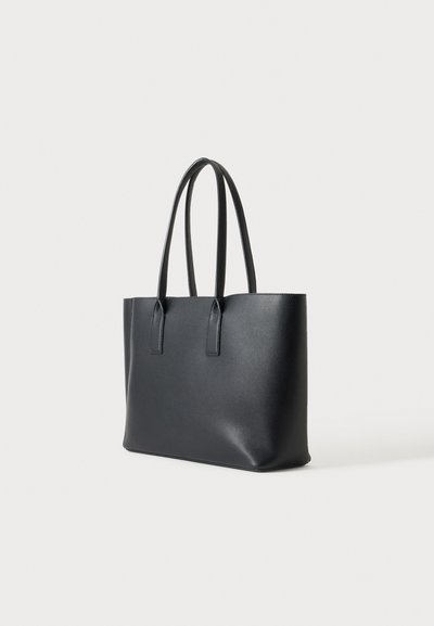 Sac cabas en cuir noir avec deux longues anses, forme rectangulaire et texture lisse sur un fond clair.