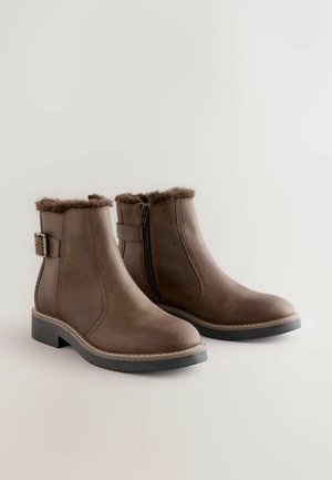 Rudi ankle boots su dirbtiniu kailiu viršuje, šoninis užtrauktukas ir dirželis. Pagaminti iš lygaus odos su žemu, storu kulnu.