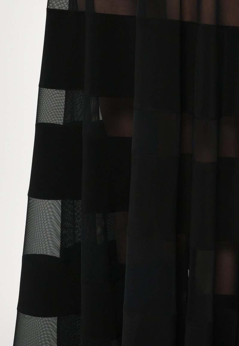 Black dress featuring a sheer, striped design with alternating solid and mesh panels, creating a layered texture and visual depth.