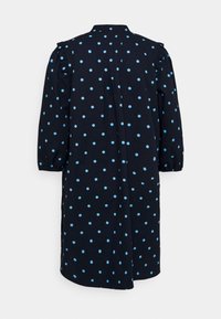 Mörkblå klänning med ljusblåa prickar, med krage, volangärmar och trekvartslånga ärmar, designad i en lös passform.
