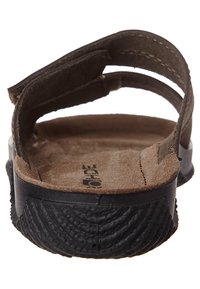 Braunes Wildledersandal mit schwarzer strukturiertem Gummisohle und verstellbarem Riemen, von hinten betrachtet.