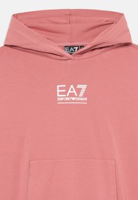 Rosa Kapuzenpullover mit einer Vorderentasche, aus weichem Stoff gefertigt. Verfügt über ein weißes EA7 Emporio Armani Logo auf der Brust. Mit Kapuze.