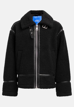 Black shearling jacket with a high collar, silver zipper, and black leather accents on sleeves and hem. Features side pockets and a label.