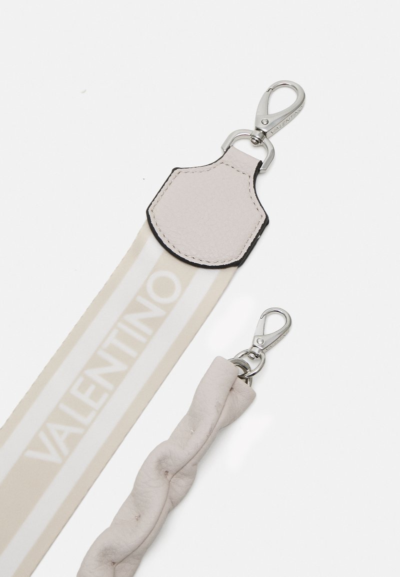 Correa de cuero en un beige claro, con un diseño trenzado y un cierre de langosta plateado. La palabra "VALENTINO" aparece en blanco en una sección a rayas.