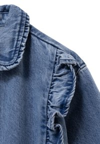 Chaqueta de mezclilla en azul claro, con una textura con volantes a lo largo de las costuras de los hombros y un diseño de cuello clásico.